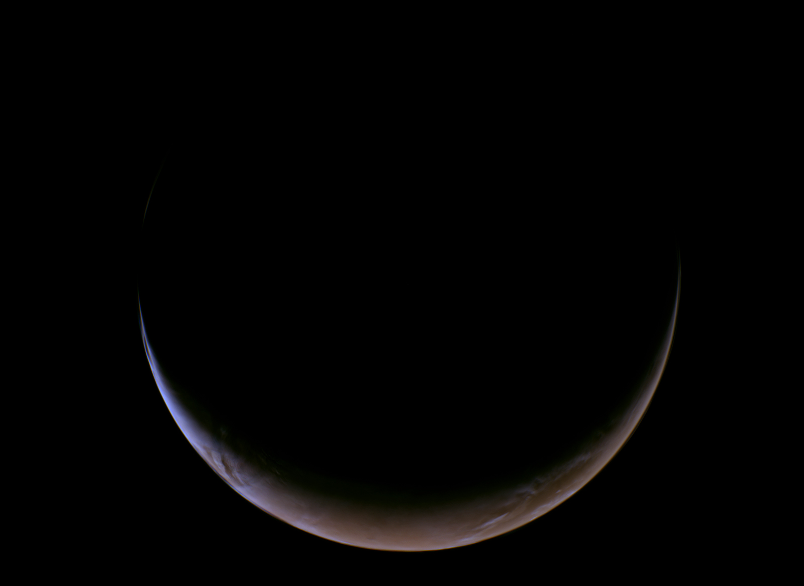 A slender, glowing crescent of Mars curves across the bottom of a completely black void, revealing its dusty reddish-orange surface and a thin, hazy blue atmospheric glow along the illuminated edge.