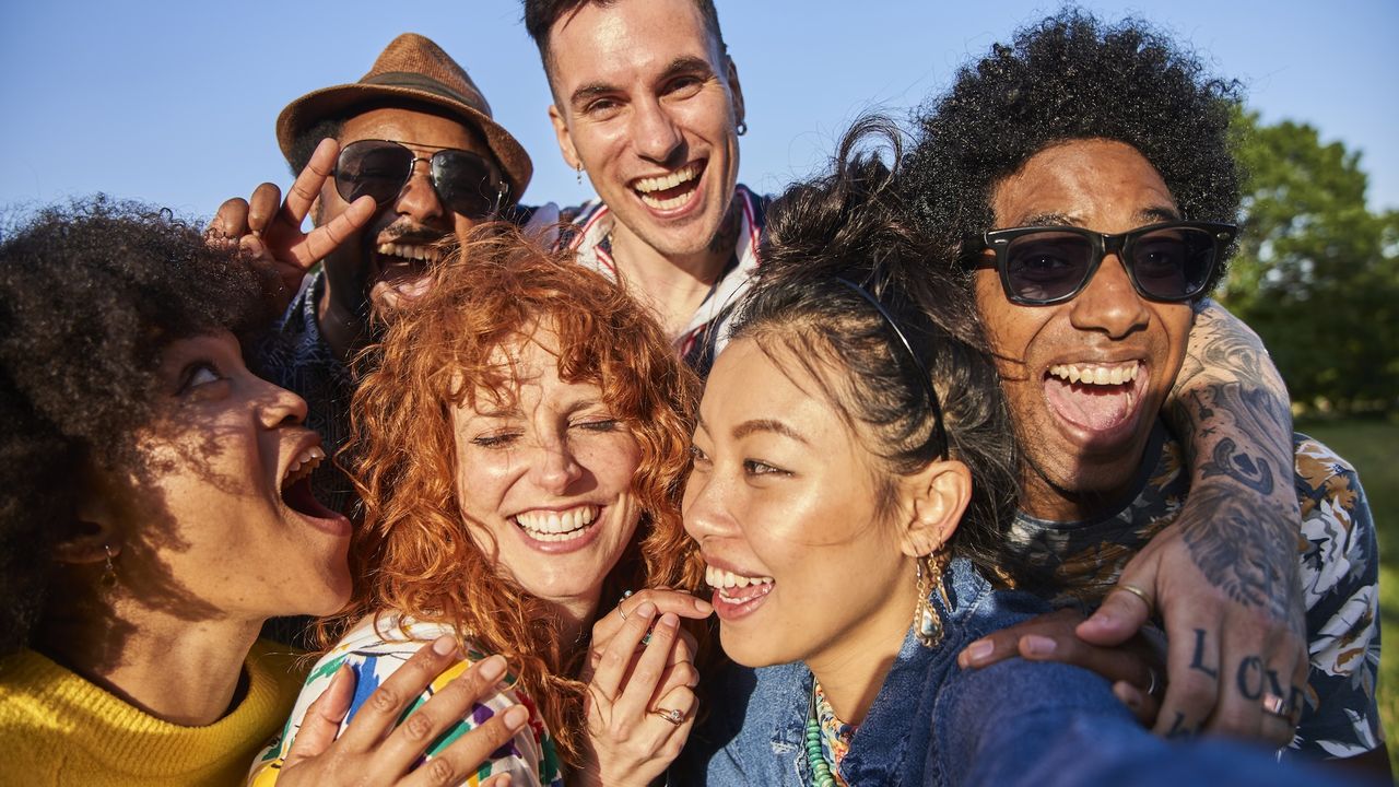 A group of people standing together while they smile and laugh