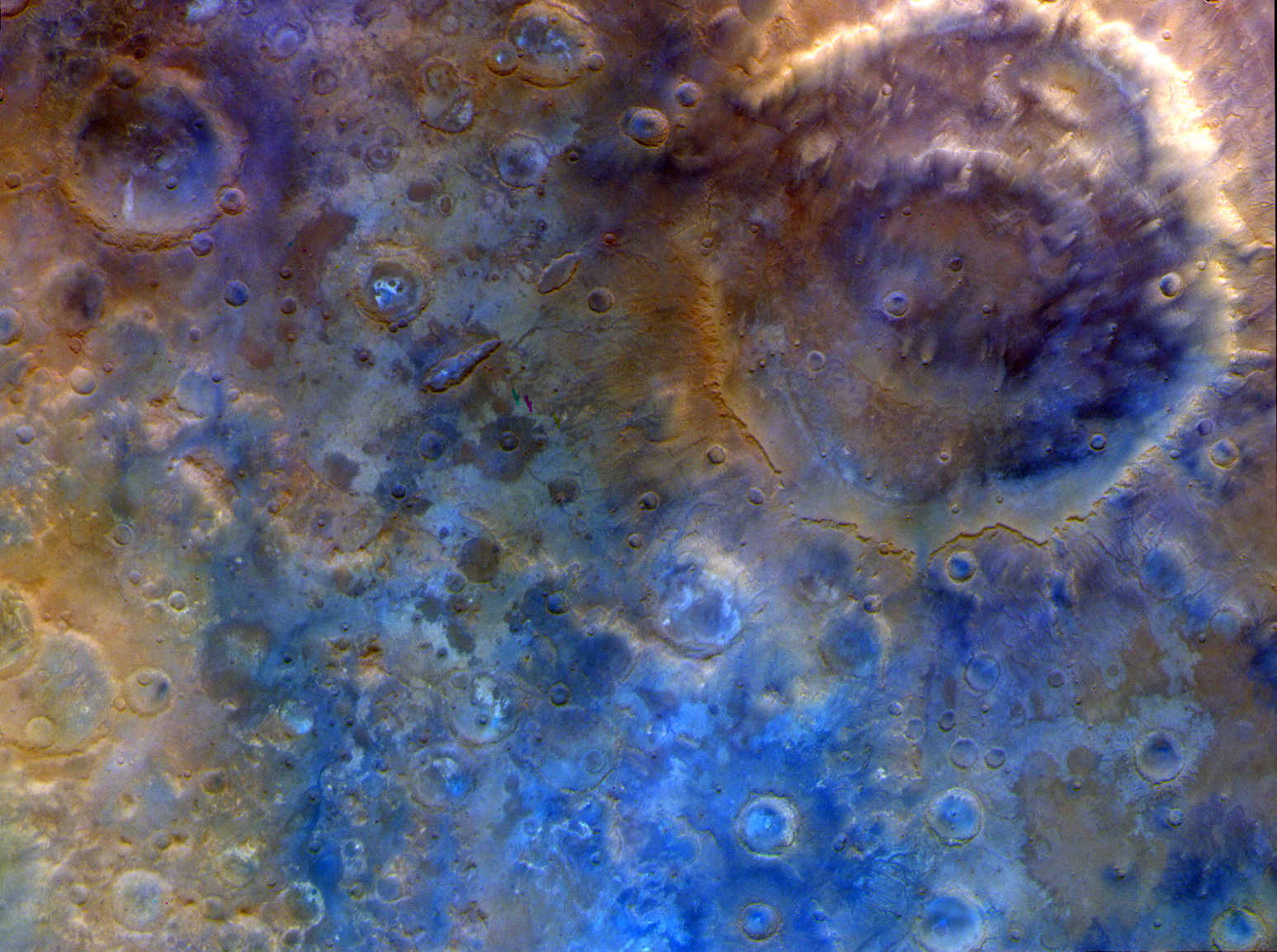 A false-color, top-down view of a Martian surface densely pockmarked with impact craters of various sizes, highlighted in vivid shades of blue, tan, and purple to differentiate geological materials.