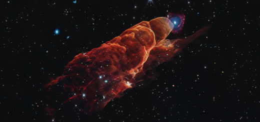 Angled from the upper left corner to the lower right corner is a cone-shaped orange-red cloud known as Herbig-Haro 49/50. This feature takes up about three-fourths of the length of this angle. The upper left end of this feature has a translucent, rounded end. The conical feature widens slightly from the rounded end at the upper right down to the lower right. Along the cone there are additional rounded edges, like edges of a wave, and intricate foamy-like details, as well as a clearer view of the black background of space. In the upper left, overlapping with the rounded end of Herbig-Haro 49/50, is a background spiral galaxy with a concentrated blue center that fades outward to blend with red spiral arms. The background of space is speckled with some white stars and smaller, more numerous, fainter white galaxies throughout.