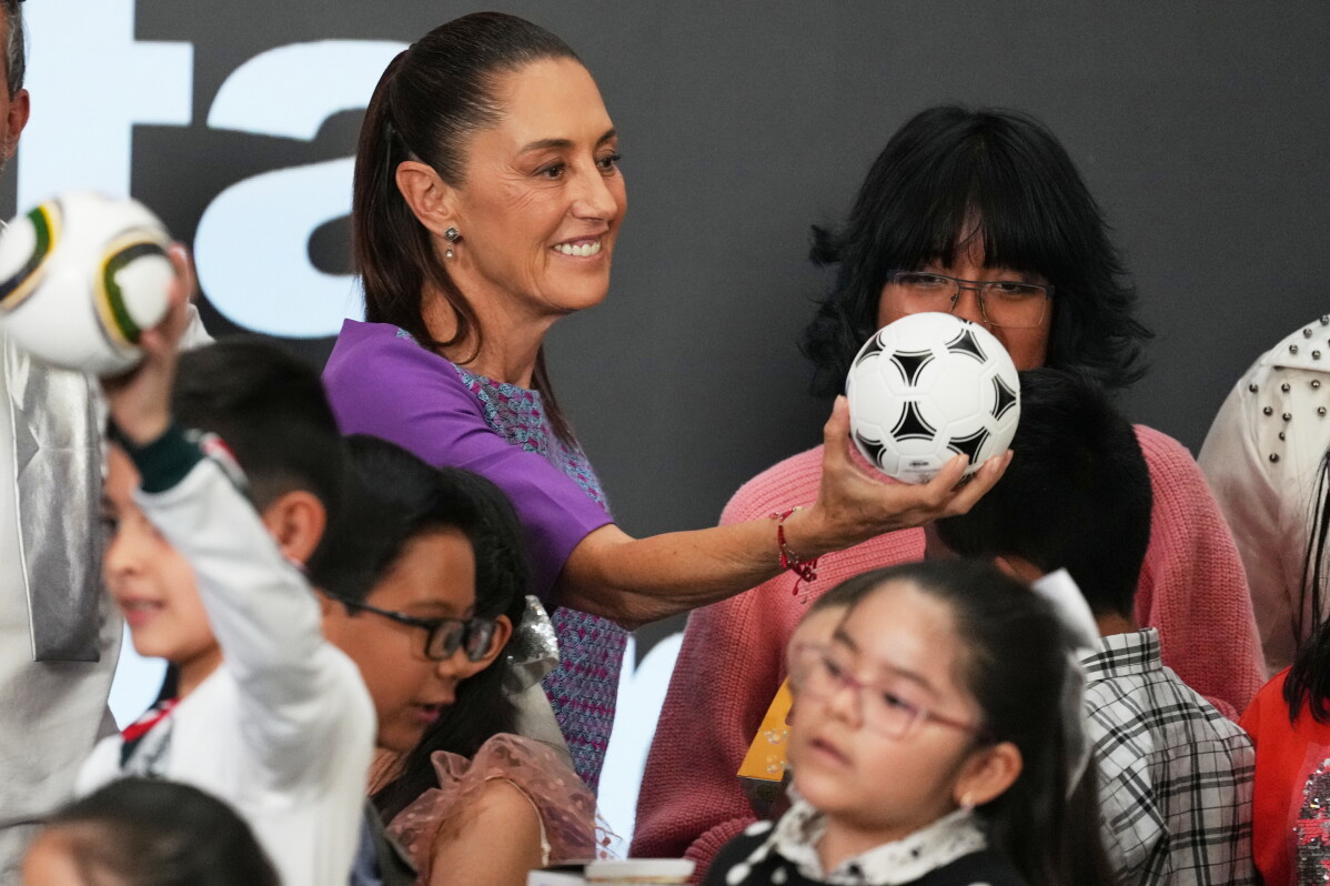 Mexican President Claudia Sheinbaum gives a soccer ball to children after her daily morning press conference at the National Palace in Mexico City, Thursday, April 30, 2026. (AP Photo/Fernando Llano)