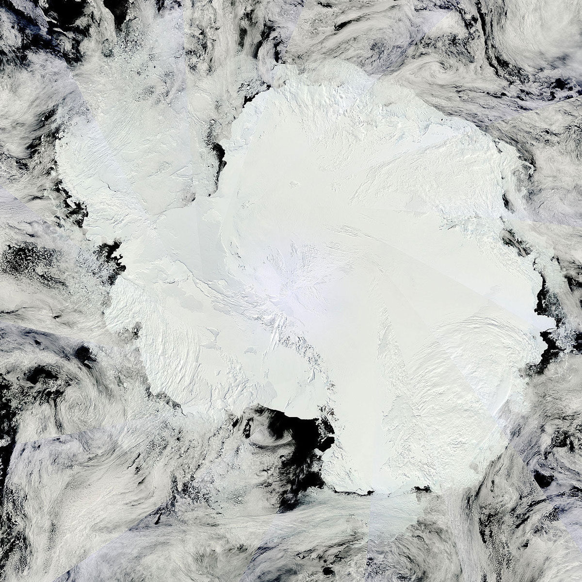 A mosaic of satellite images shows the Antarctic continent under clouds.