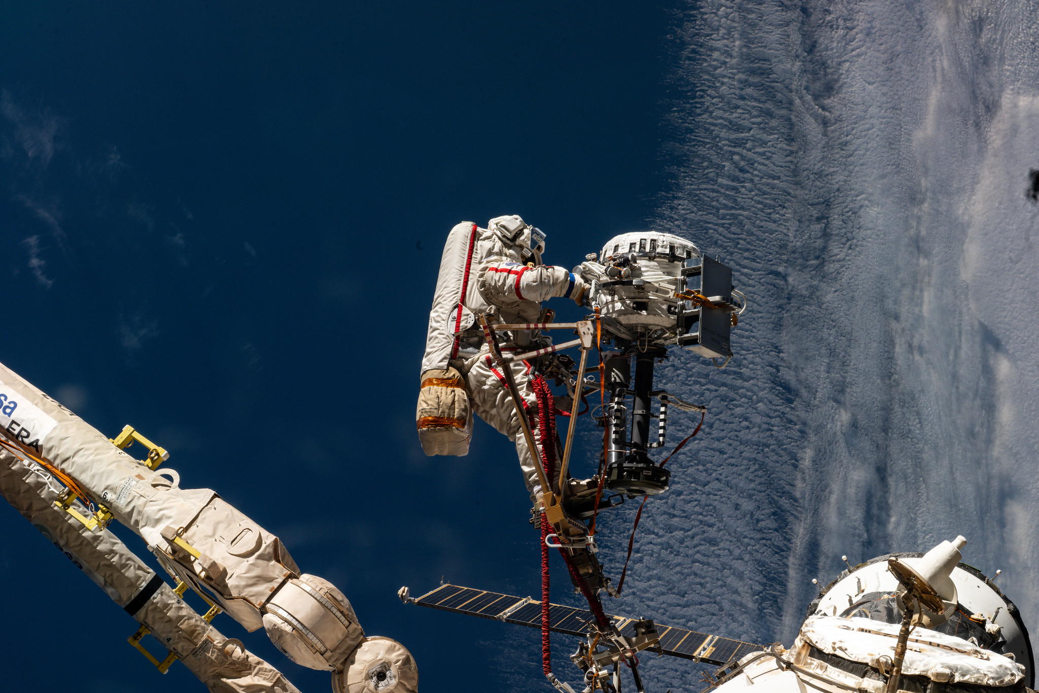 Roscosmos cosmonaut Sergey Ryzhikov is pictured at the end of the European robotic arm as he works on a high‑resolution camera during a six‑hour, nine‑minute spacewalk outside the International Space Station on Oct. 16, 2025