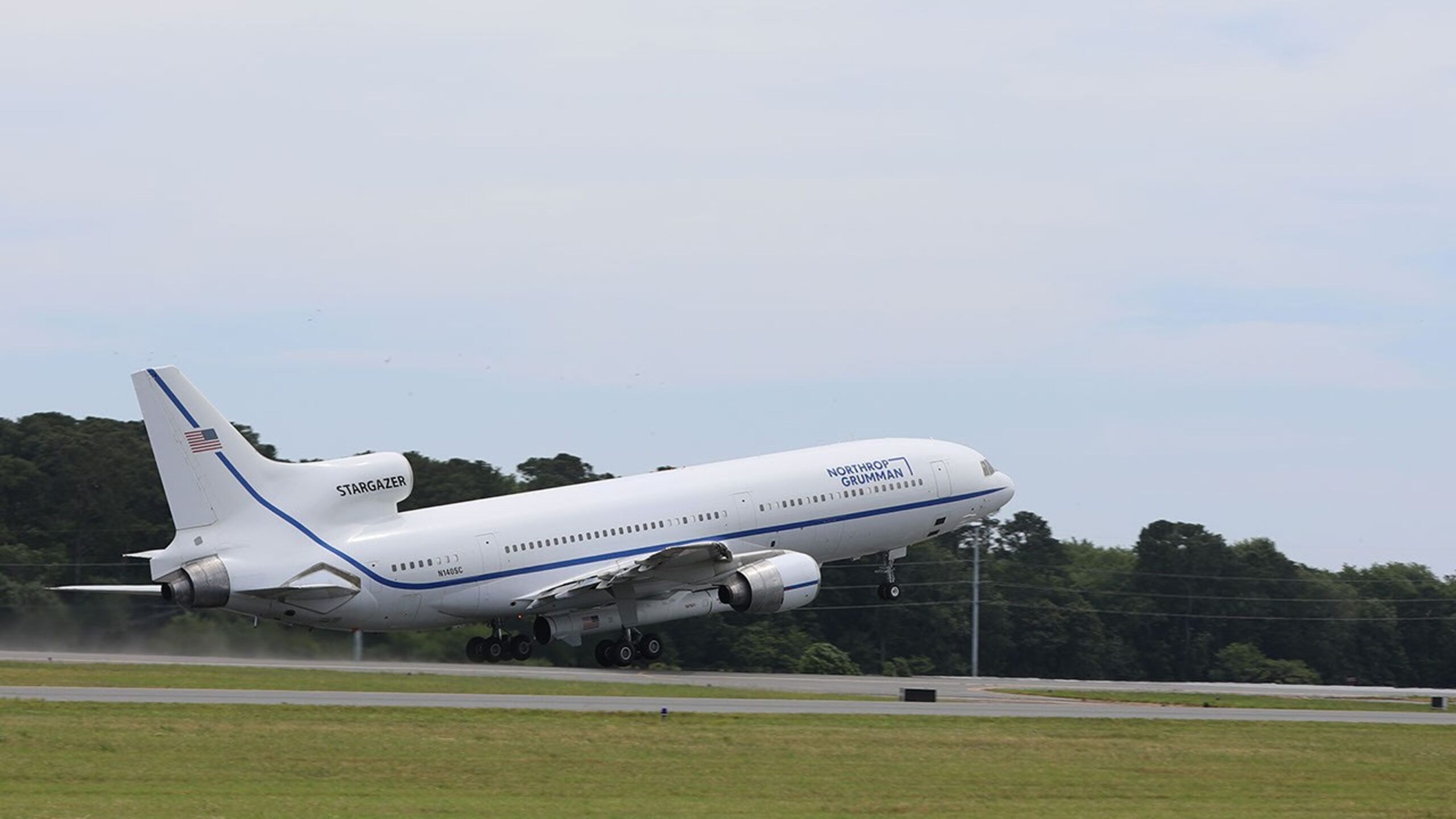 An airplane taking off with a rocket attached to the fuselage