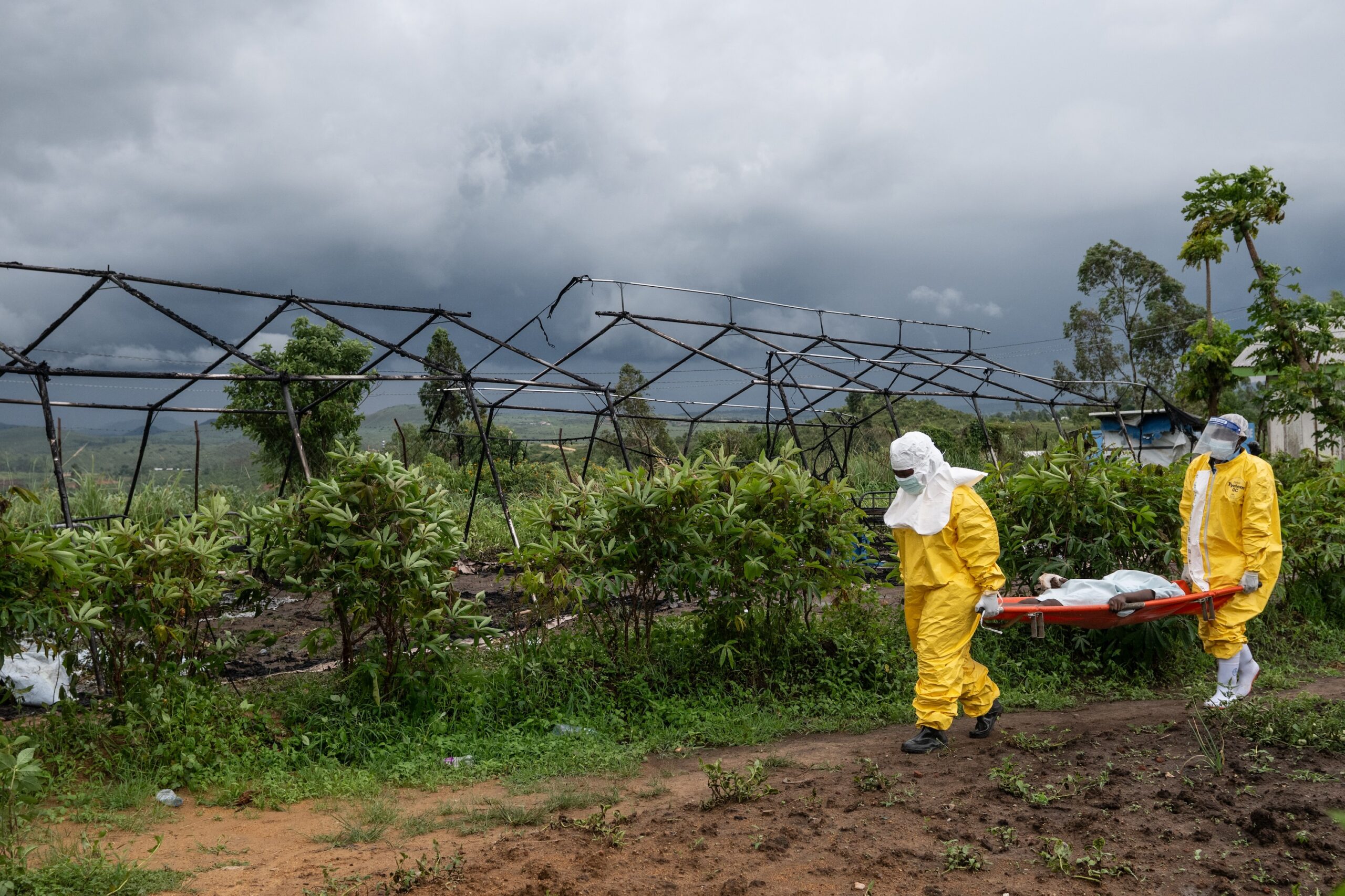 Medical staff carry an Ebola patient to a treatment center. Image by Moses Sawasawa via Associated Press.
