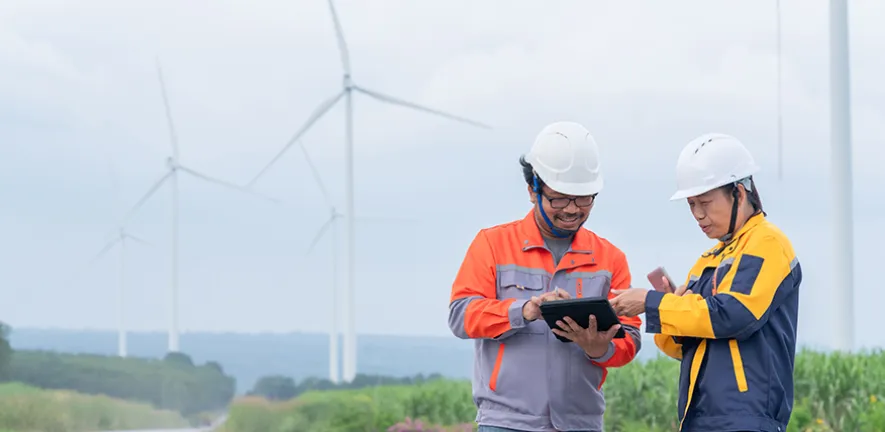 Two engineers standing in front of wind turbines
