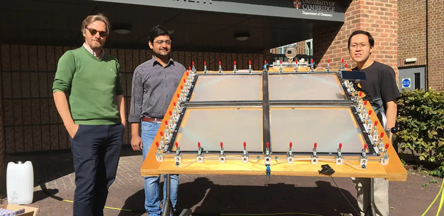 Reisner and team with the solar-powered reactor that can convert plastic waste into clean hydrogen fuel outside Cambridge University's Chemistry Department.