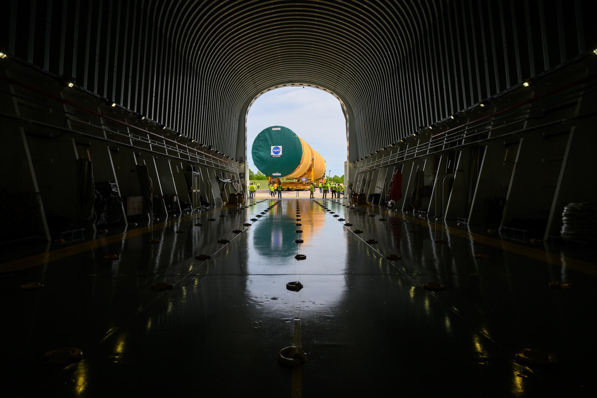 NASA moved the core stage, or the largest section, of the SLS (Space Launch System) rocket that will launch the crewed Artemis III mission in 2027 from the agency’s Michoud Assembly Facility to the agency’s Pegasus barge in New Orleans on April 20. The barge will ferry the top four-fifths – the section containing the liquid hydrogen tank, liquid oxygen tank, intertank, and forward skirt – of the SLS core stage to NASA’s Kennedy Space Center in Florida to complete outfitting and vertical integration. Teams with NASA and Boeing, the SLS core stage lead contractor, used specialized transporters to guide the top four-fifths from the NASA rocket factory to Pegasus. Prior to the move, technicians added an engine section transportation simulator to the rocket stage for shipment to the Space Coast. Next year’s Artemis III mission will launch astronauts to Earth’s orbit aboard the Orion spacecraft on top of SLS to test rendezvous and docking capabilities between Orion and commercial spacecraft needed to land Artemis IV astronauts on the Moon in 2028. NASA’s SLS is the only rocket capable of sending Orion, astronauts, and supplies to the Moon in a single launch.