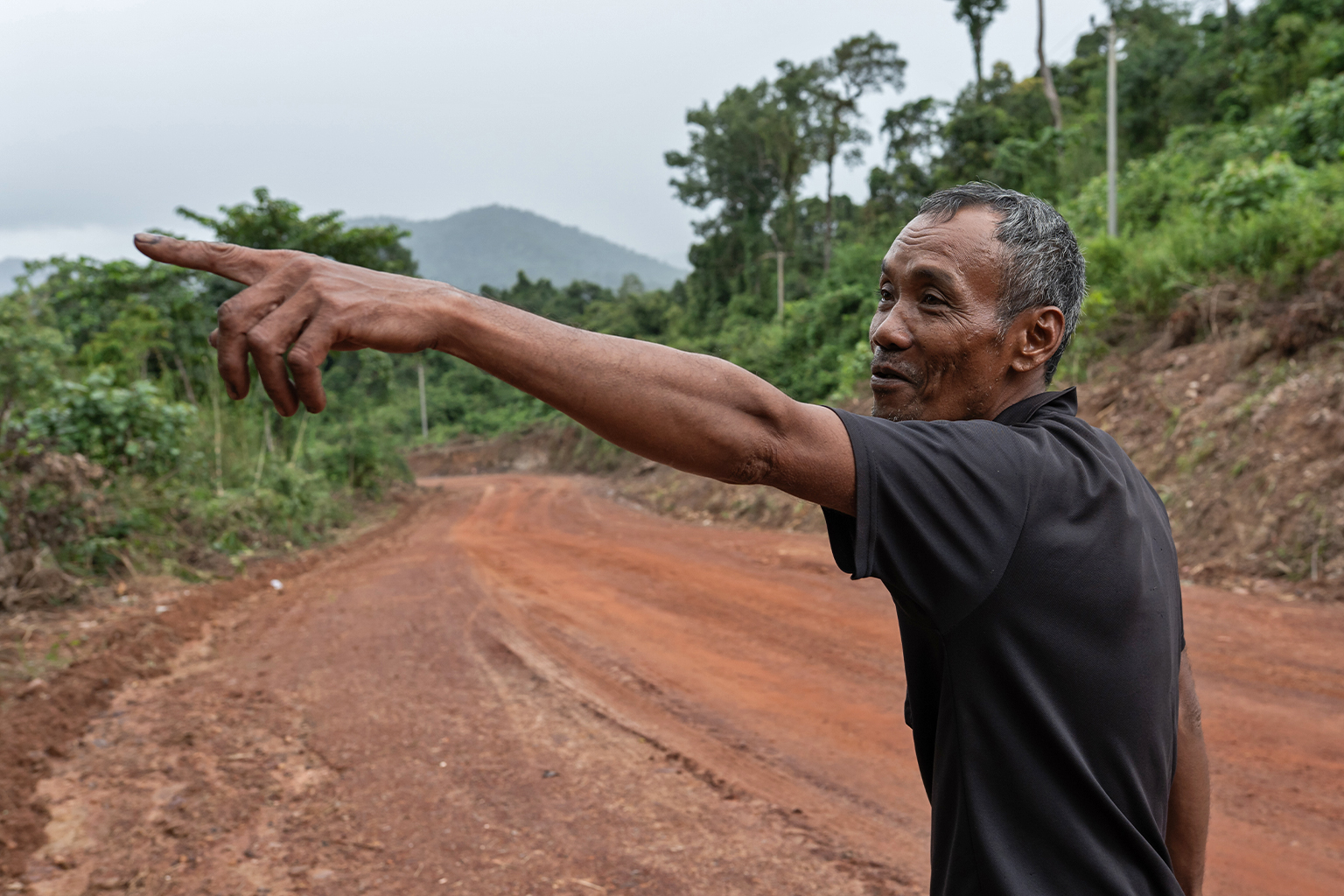 Sat Born, 56, points to the spot where he claims to have seen a tiger (Panthera tigris) on a morning in 2001 while on his way to the forest to collect ratan.