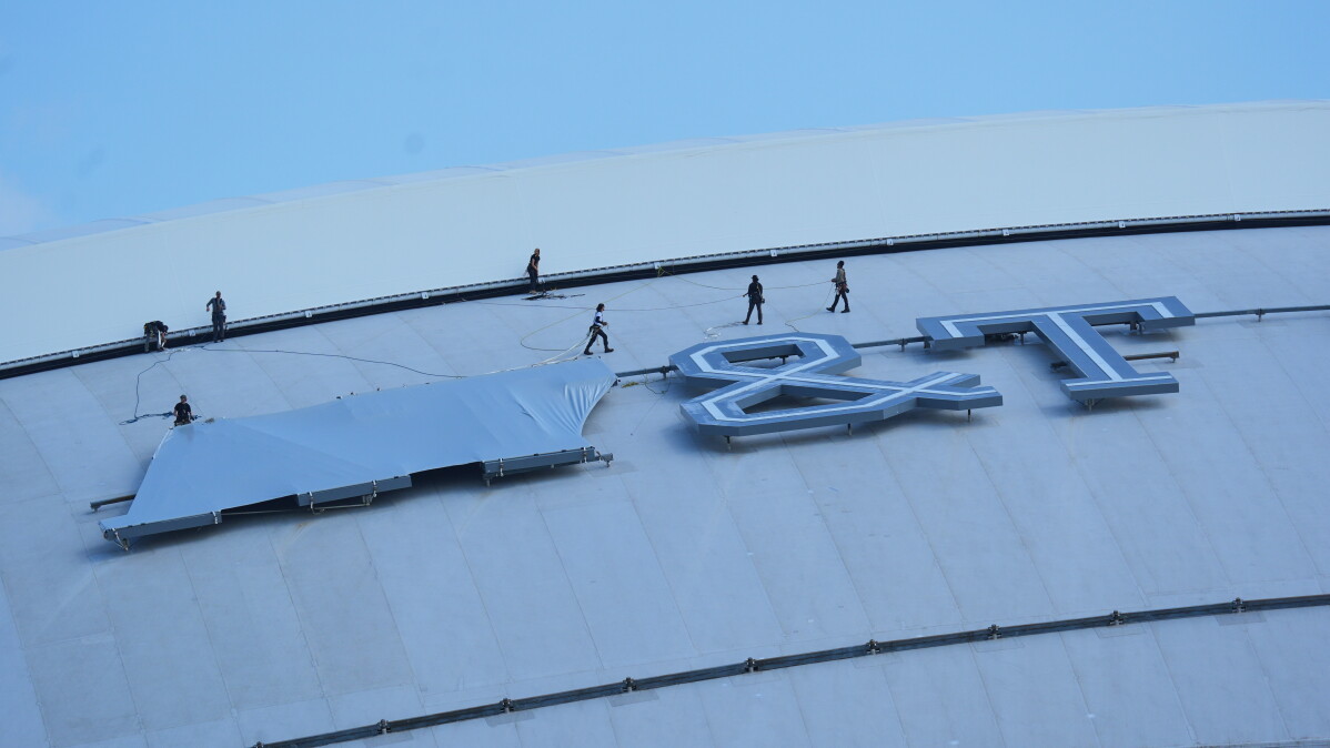 Workers cover signage on the exterior of AT&T Stadium, which will be named Dallas Stadium during the 2026 FIFA World Cup soccer tournament, as preparations continue at the venue, Tuesday, June 2, 2026, in Arlington. (AP Photo/LM Otero)