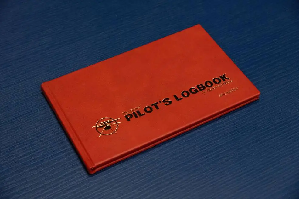 A red Pilot's logbook on a blue background.
