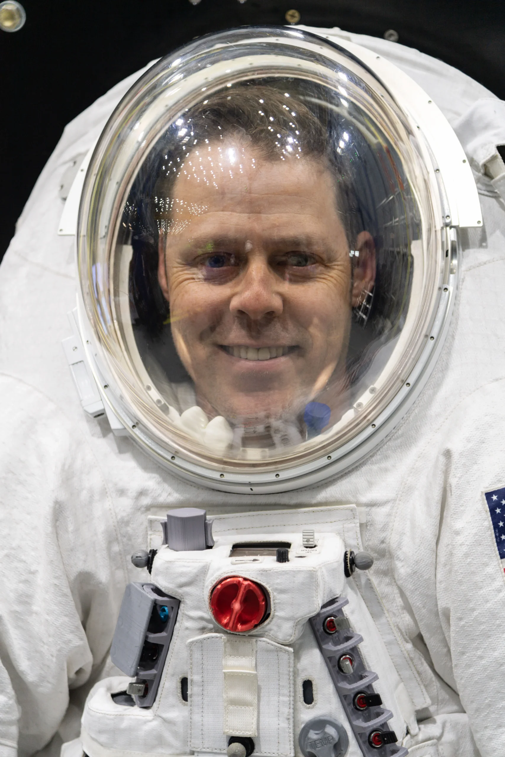 Scott Wray smiles from inside NASA’s Exploration Extravehicular Mobility Unit.