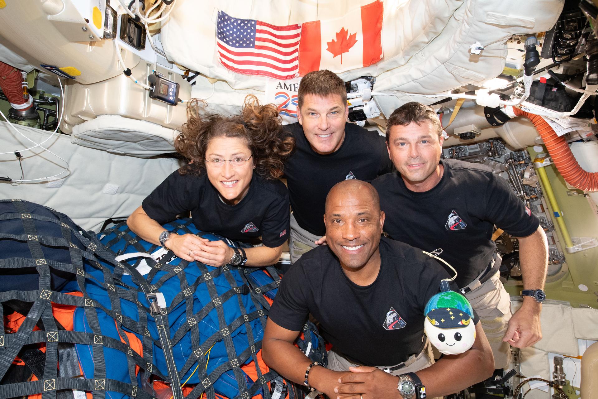 La tripulación de Artemis II hace una pausa para una foto de grupo con su indicador de gravedad cero “Rise”, dentro de la nave espacial Orion de camino a casa.