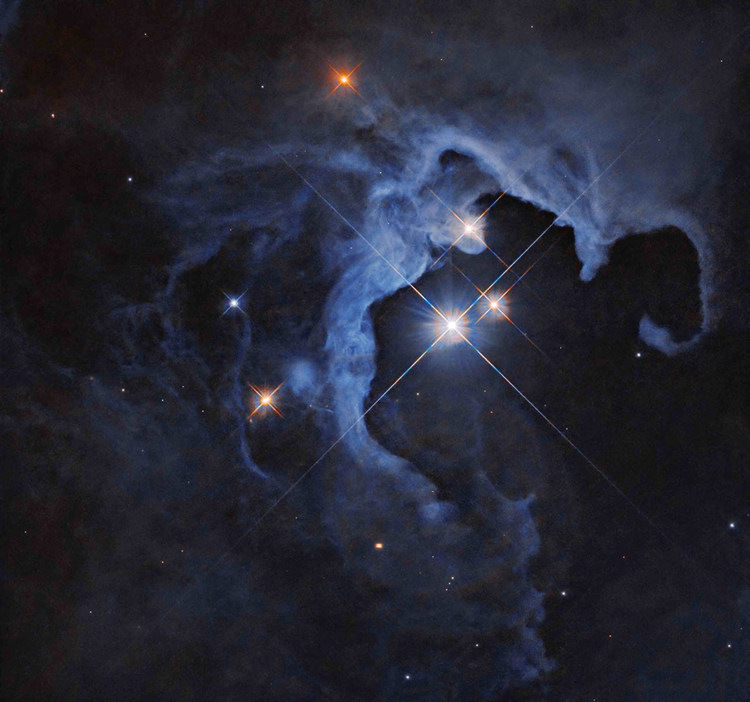 NASA’s Hubble Captures Crimson Cloud Sparkling with White, Blue Stars